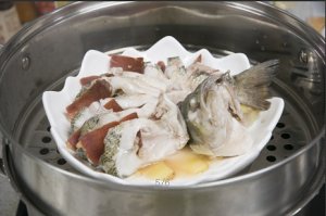 將鱸魚成花狀擺好，將火腿切片放入各縫隙中，放入鍋中隔水蒸12分鐘拿出，撒上蔥花即可。