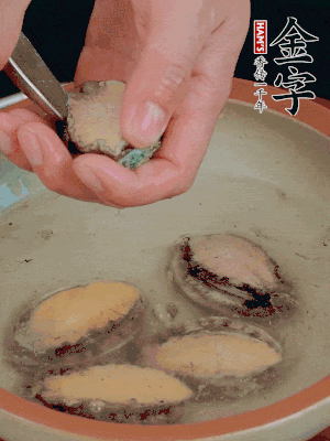 鮑魚加鹽、清水浸泡，用勺子挖出鮑魚肉。