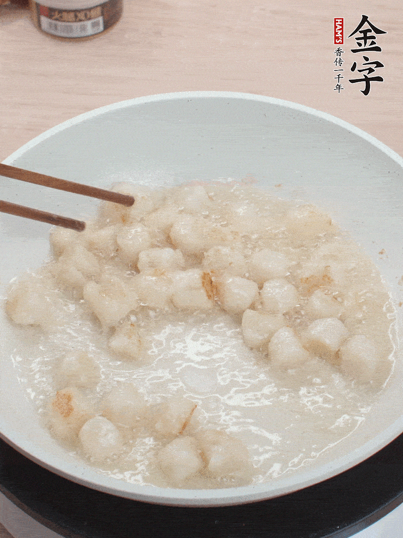 油溫4成熱，鮮貝蘸干淀粉下鍋煎，一面微黃后翻面。