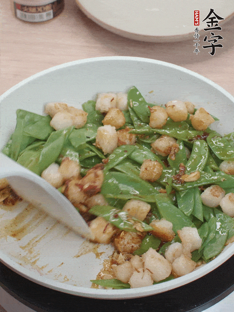 下甜豆莢、鮮貝輕輕翻炒均勻。